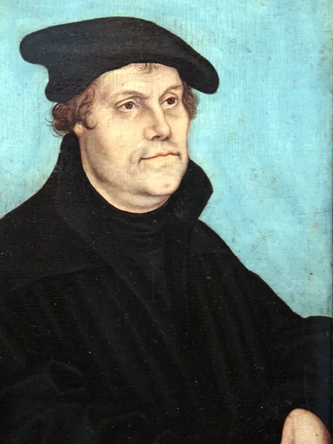 Retrato pintado de Martinho Lutero com barrete e veste escuros.